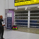 Airport Meet And Greet Sheffield airport meet and greet service showing our driver golding a sign with customer details awaiting their arrival outside the airport information kiosk