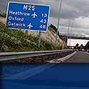 airport taxi sign on a motorway stating miles to london airports
